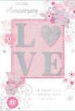 This anniversary card is captured as though resting on a tidy sideboard in a Finsbury Park flat, quietly glowing in tones of pastel pink, pearly white, and soft silver. The focus of the design is the word LOVE, spelled out in raised glitter letters that are silky to the eye and likely slightly rough to the touch, as if dusted with fine sugar. The letterforms sit neatly on a blush-pink block at the centre, giving them structure and importance, much like the focal blooms in a carefully composed anniversary bouquet. Radiating from this centrepiece, illustrated flowers in blush, mauve, and ivory unfurl, their petals flowing into curved vines and stylised leaves. Each is outlined and softly shaded with gentle grey and silver touches, creating the impression of a light pencil sketch brought to life with watercolour washes. The overall floral pattern drifts across a pale pink background, airy and uncluttered, evoking the soft romance of an English spring garden. Tiny details-curling tendrils, miniature petals, and subtle butterflies-tuck themselves between the blooms, adding a hint of movement and playful whimsy. Elegant, flowing script spells out anniversary greetings, including sentiments like On Our Anniversary and I love you today and always, the lettering poised and refined yet warmly personal. The mood is intimate and sincere, like sharing flowers and quiet words after a walk through the park's tree-lined avenues. This card feels like a keepsake designed to accompany a fresh anniversary arrangement delivered to loved ones around Finsbury Park and nearby streets.